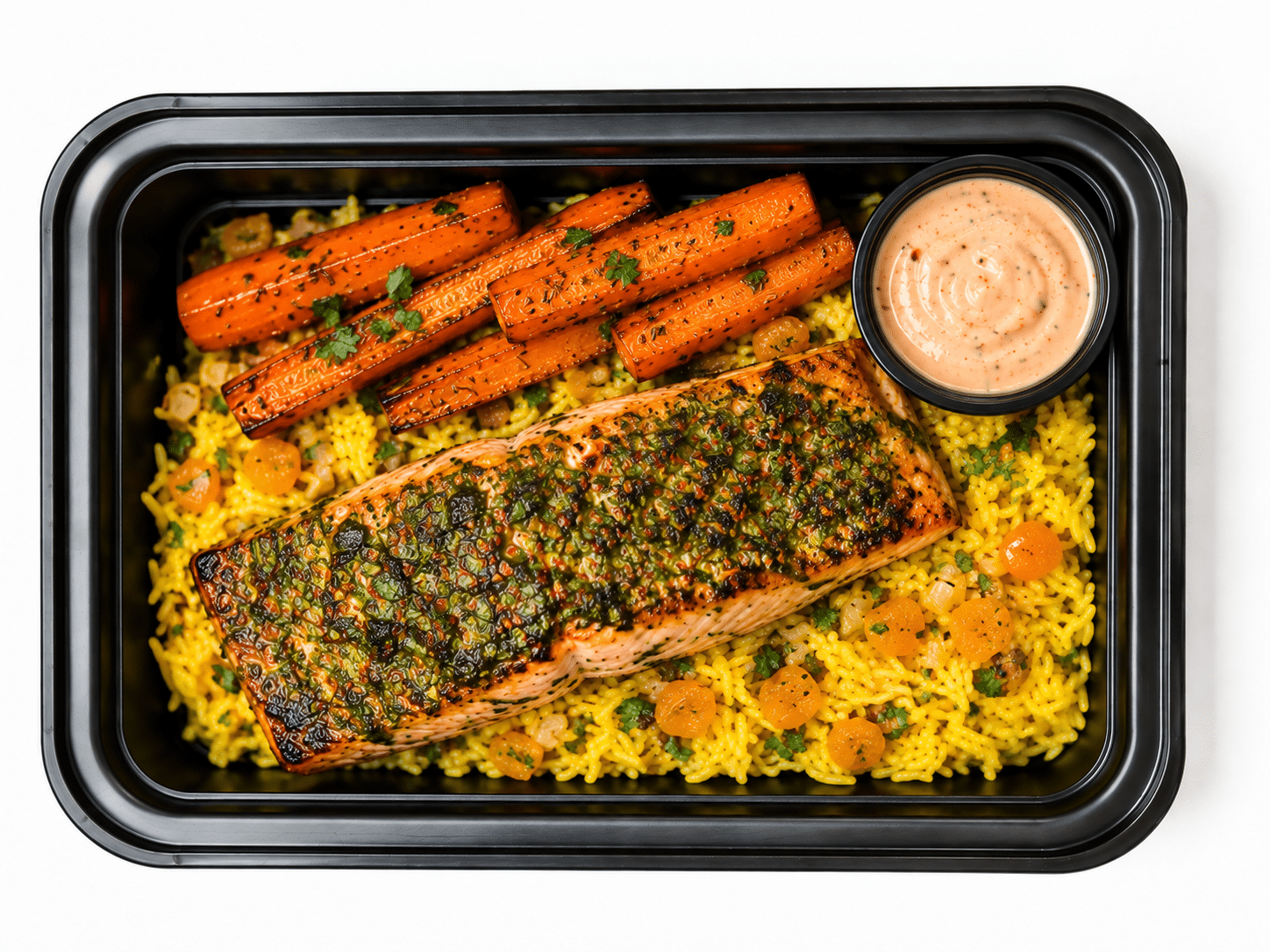 Chermoula salmon meal prep tray with saffron apricot rice, cumin-roasted carrots and harissa yogurt
